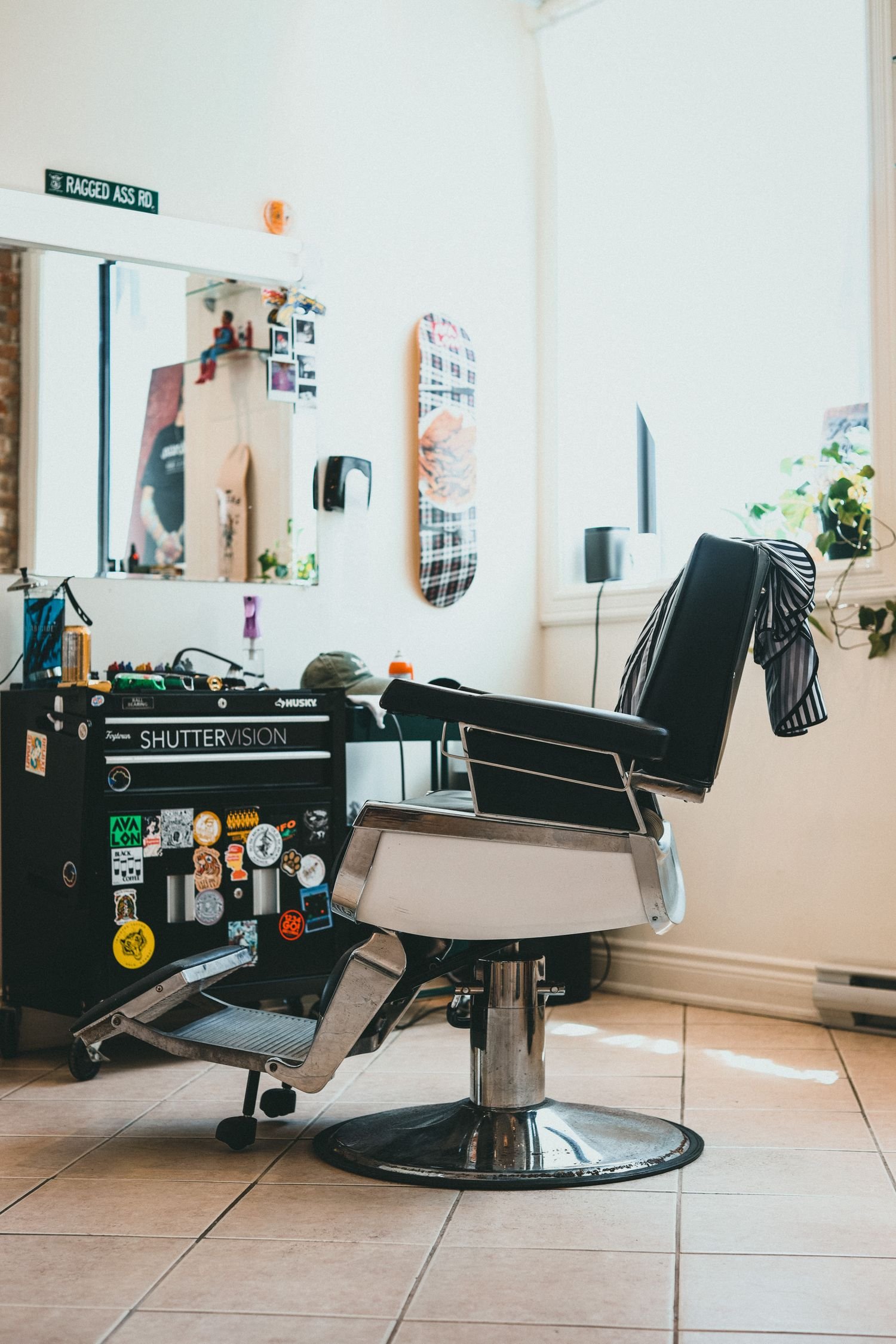 Cadeira de barbeiro e espelho em um canto da barbearia